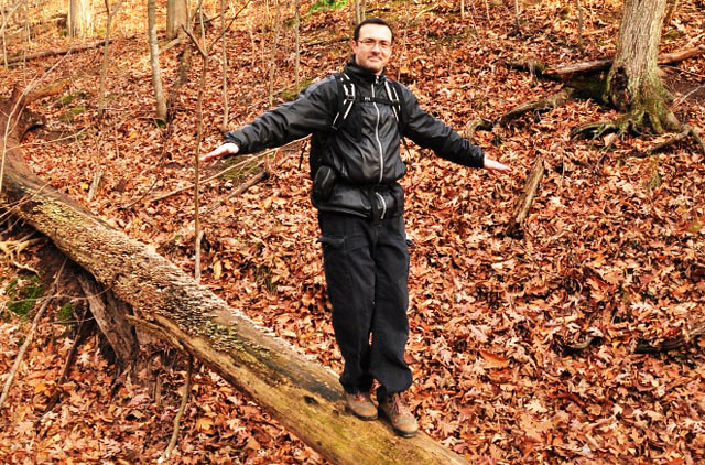 Man balancing on a log - benefits of hiking. 