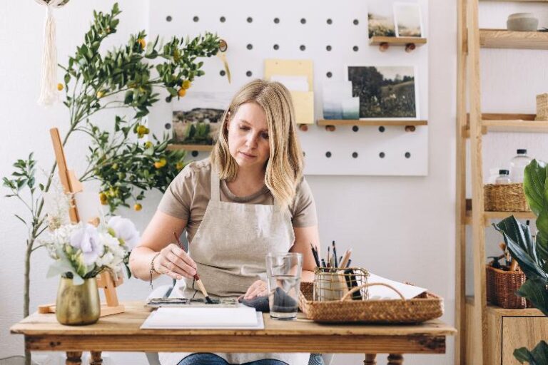 Woman painting artwork on a table - hobby ideas.