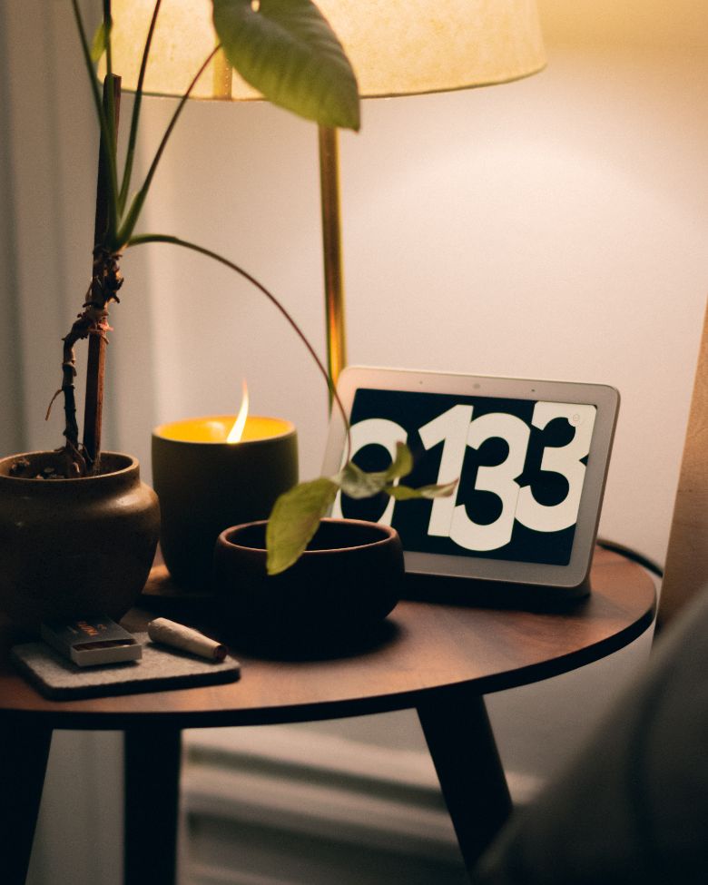 Bedtime routine for adults - dim lighting with a candle and flower by the bedside.
