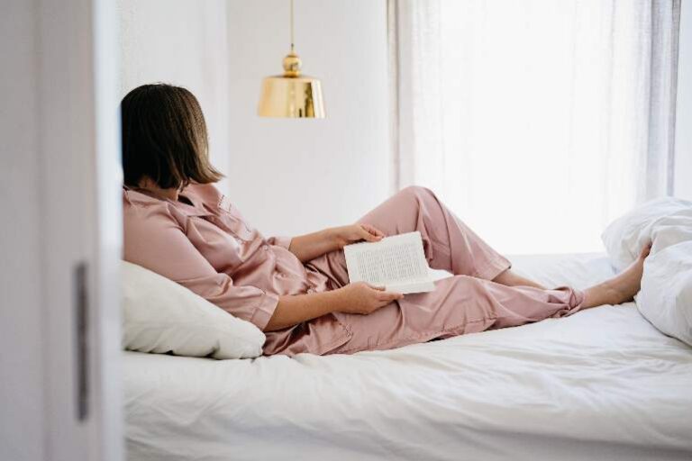 Woman in bed, with a book - relaxing Sunday night routine