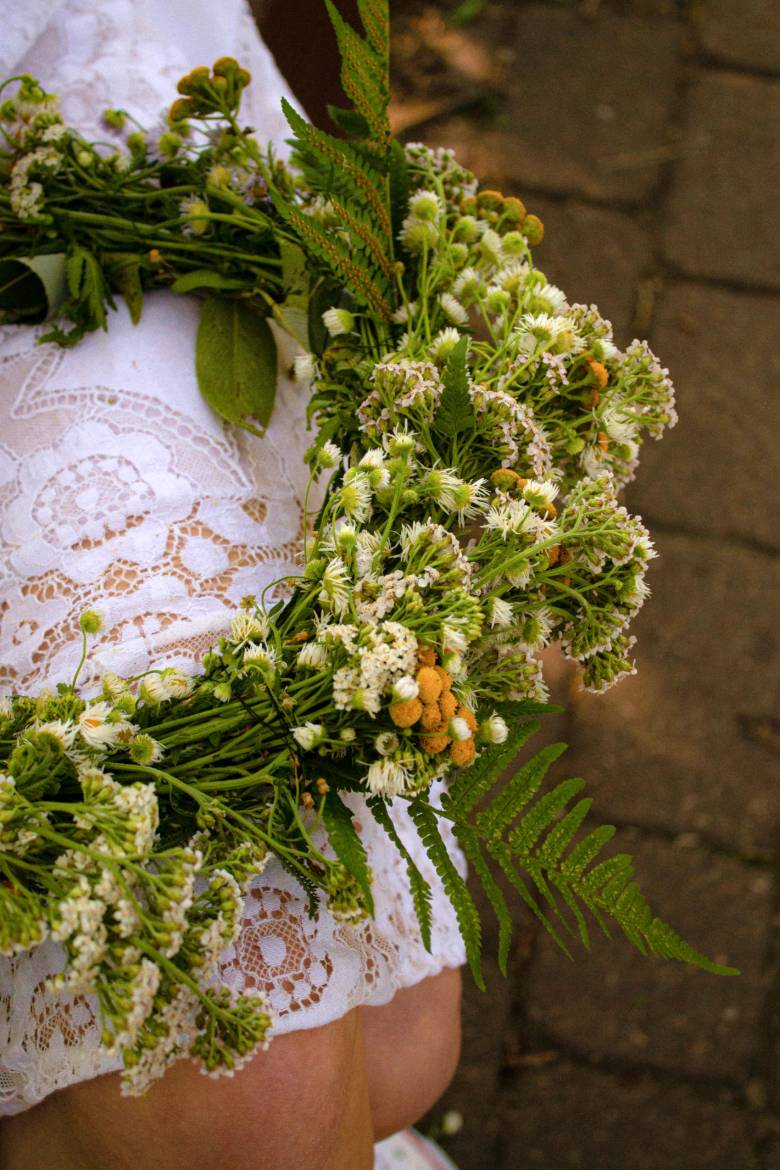 Wildflower wreath resting on a woman's white skirt - fun Spring self-care ideas.