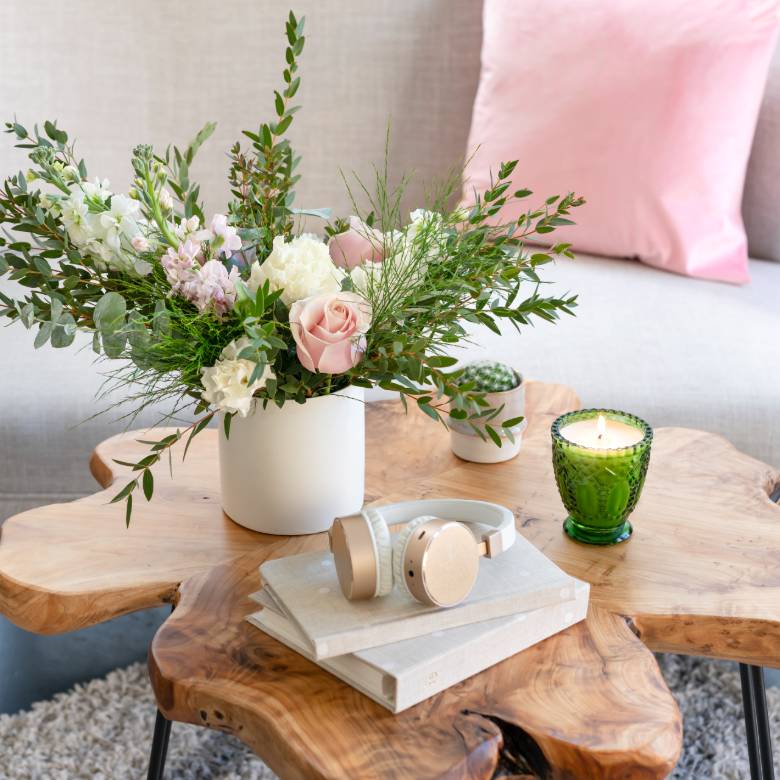 Flowers in a vase, books, pink earphones and a candle - contact SuburbanTourist.